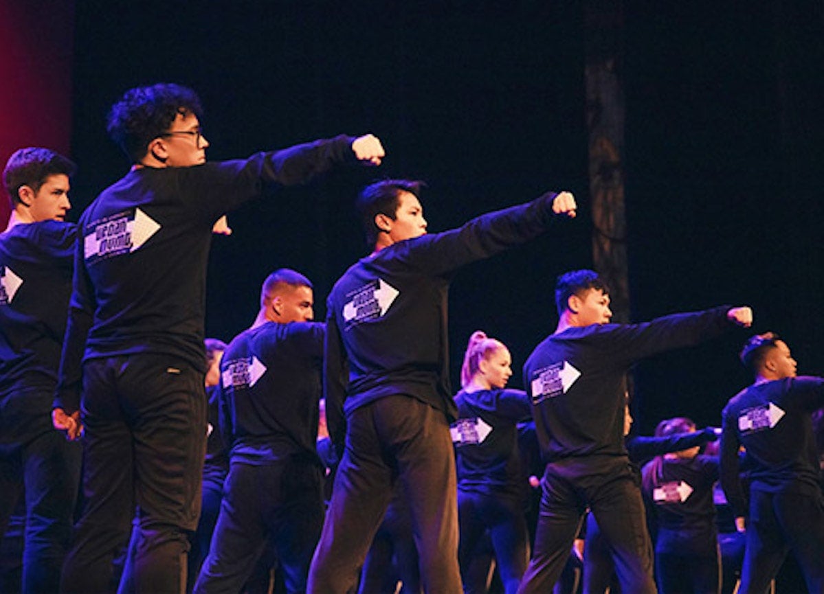 Students dancing on stage in previous Illuminate program