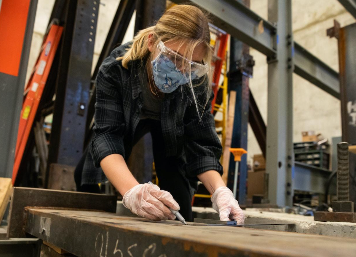 Masked Cal Poly Student works on Architecture project inside