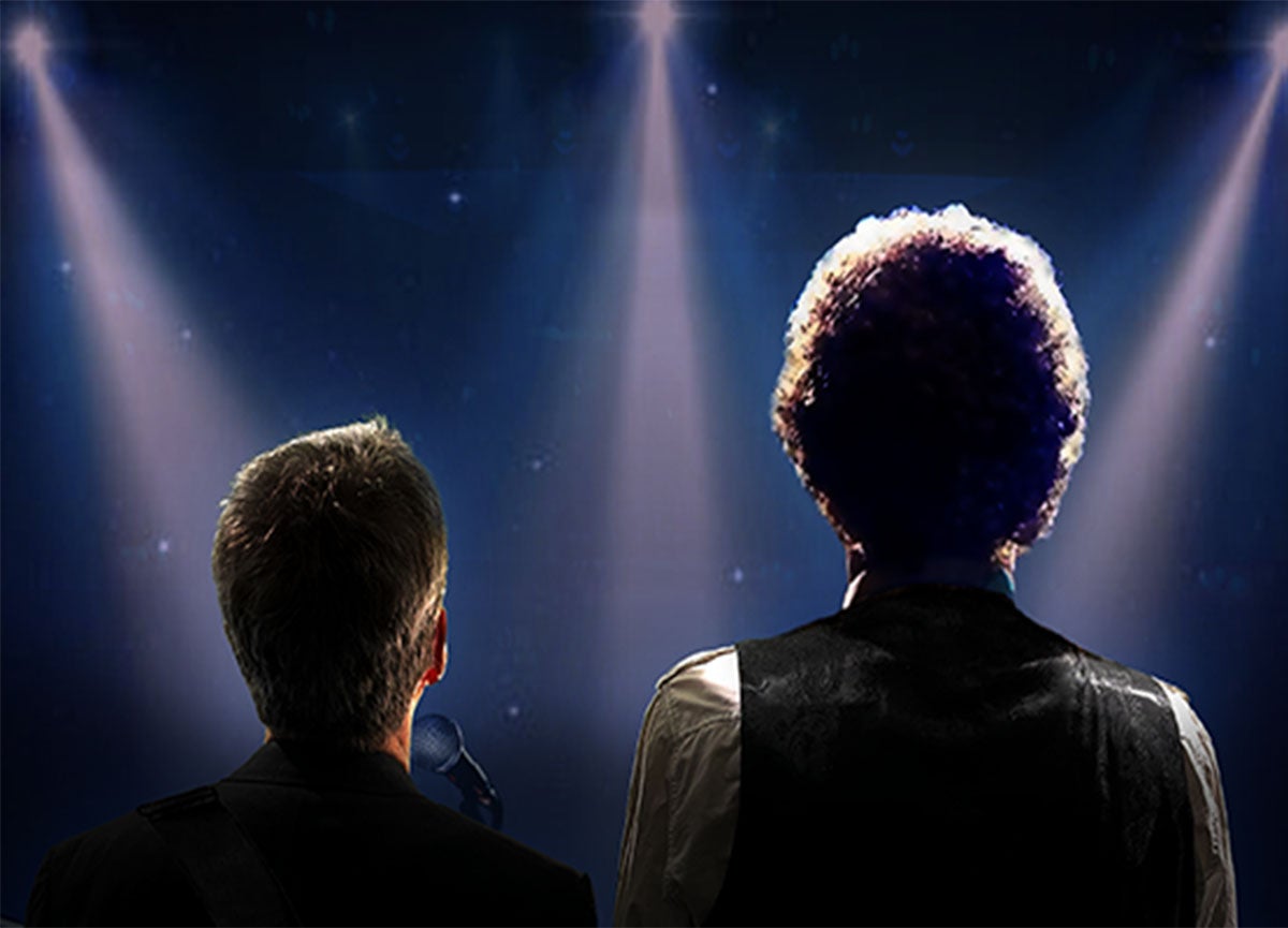 Two silhouettes facing three spotlights in a dark space. 