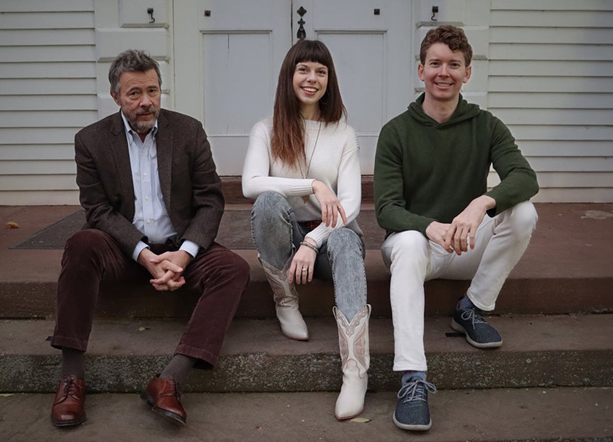 Three people sitting on steps.
