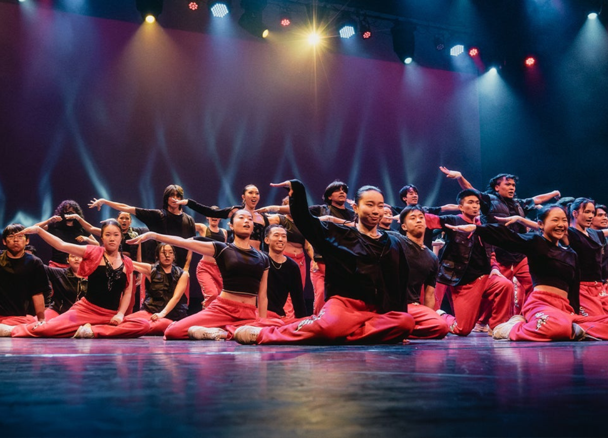 Dancers on stage pose.