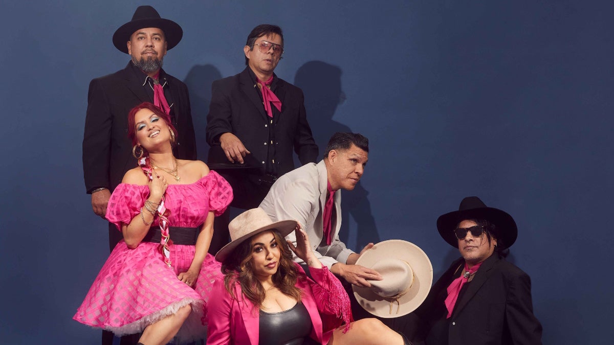 Photo of Las Cafeteras band members posed on blue background.