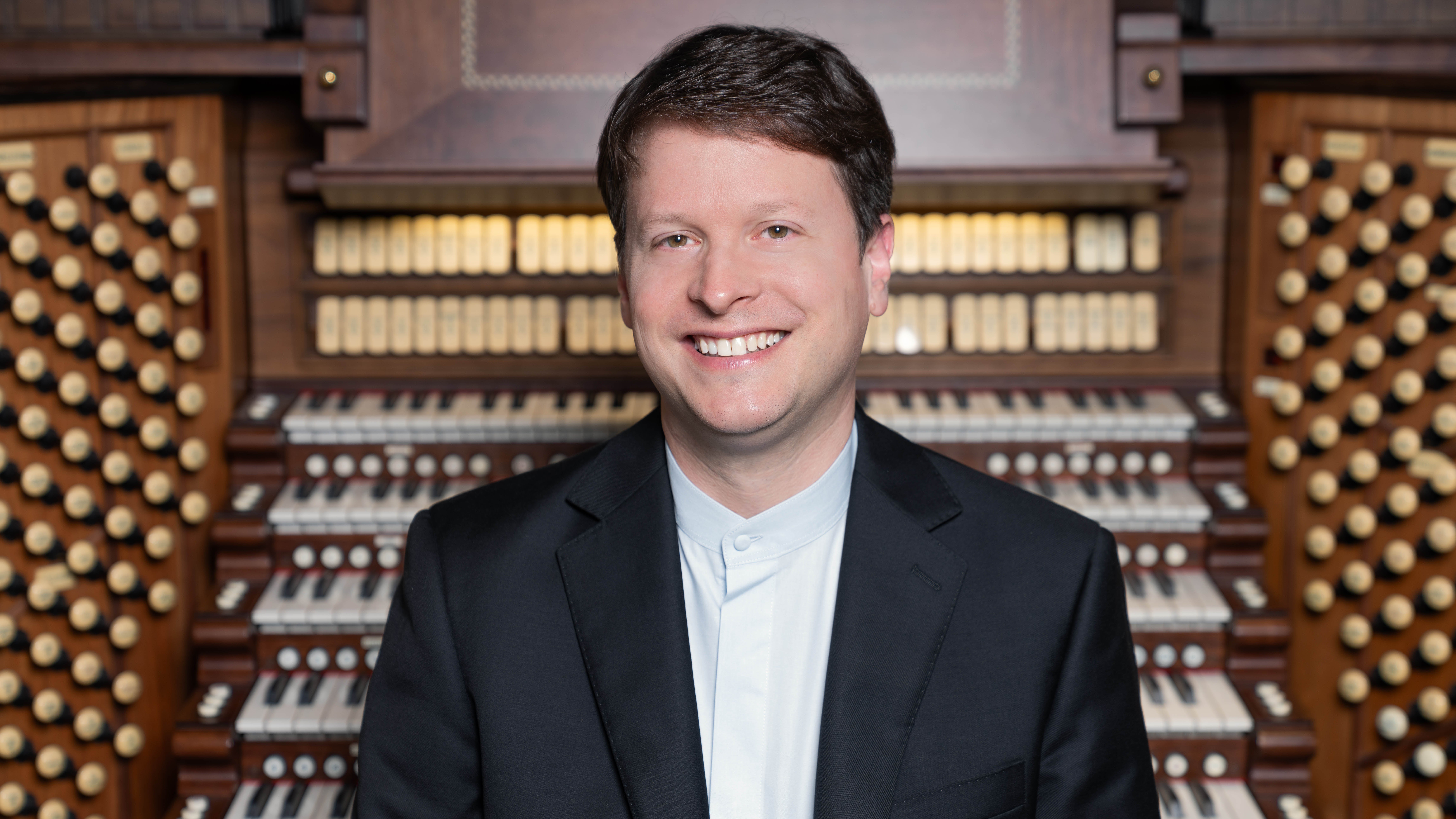 A headshot of Paul Jacobs with an organ in the background.