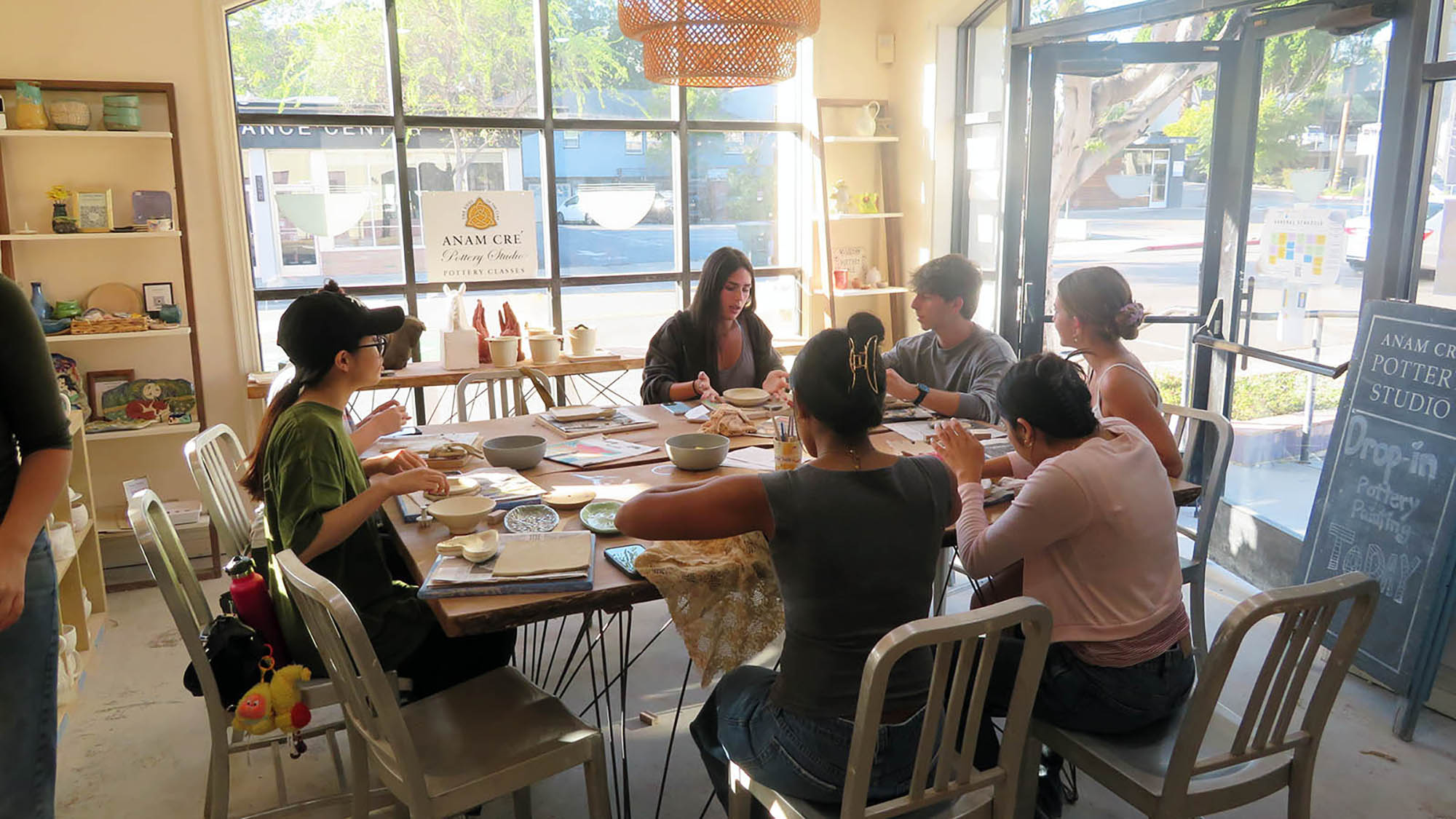 Students painting pottery at Anam Cre Pottery Studio.