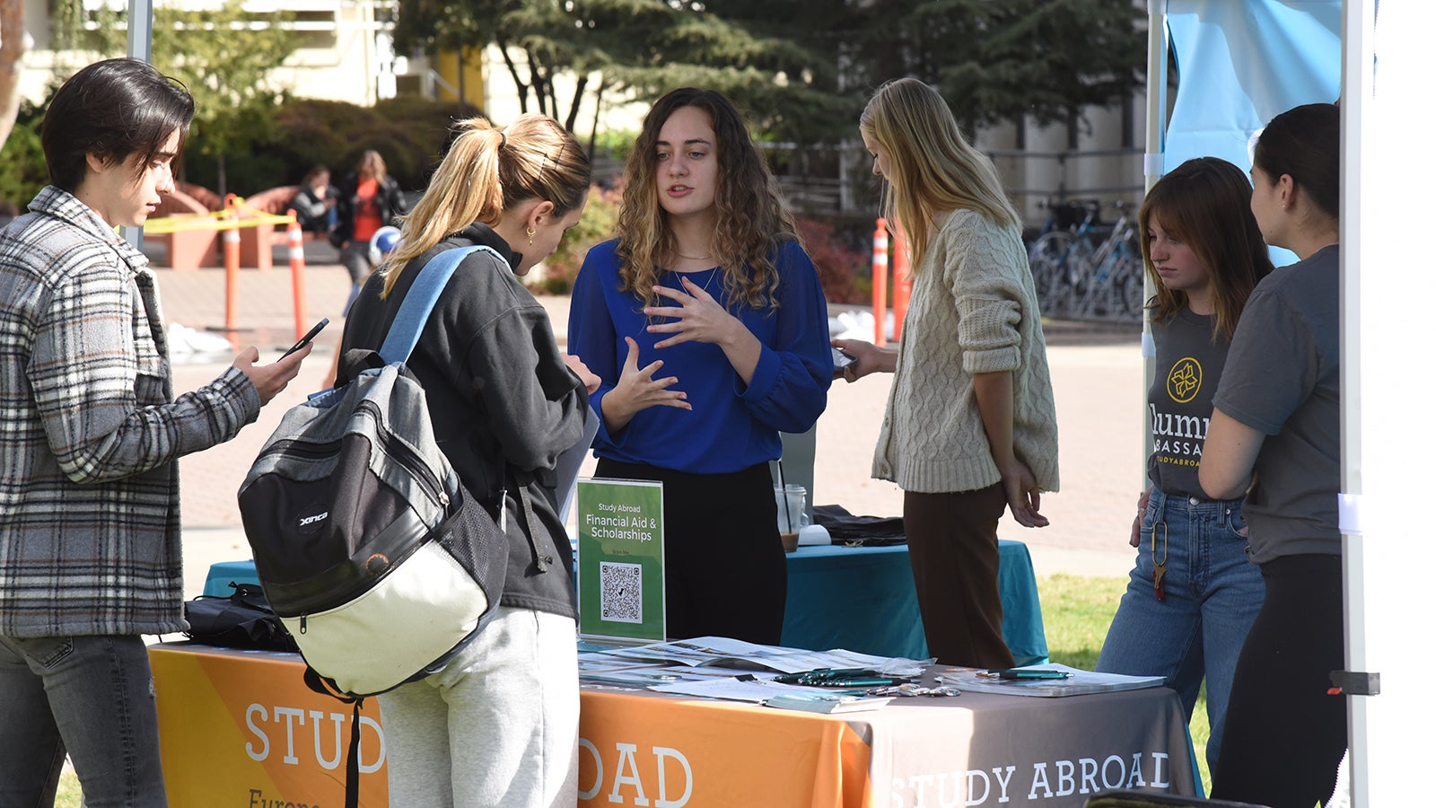 Students talking to a representative at an International Education Week informational booth.