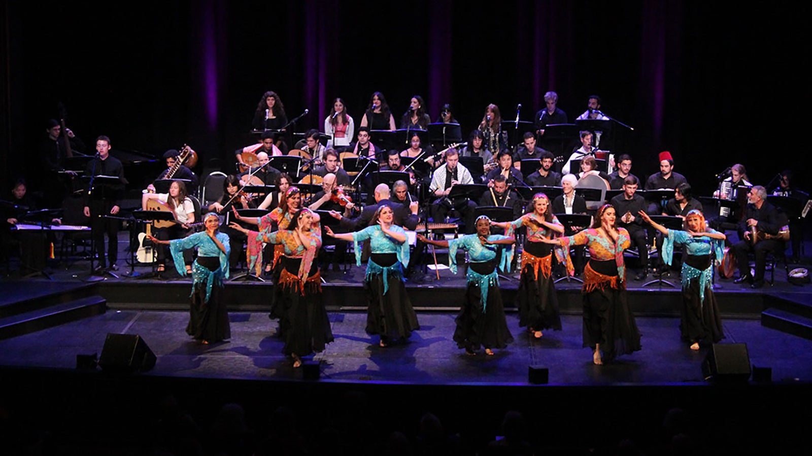 The Arab Music Ensemble and dancers performing on stage.