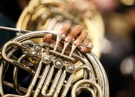 A member of the Wind Ensemble playing the French Horn