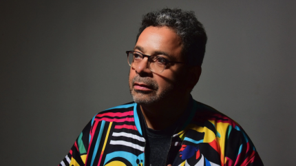 A headshot of Arturo O'Farrill in a colorful jacket.