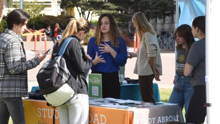 Students talking to a representative at an International Education Week informational booth.