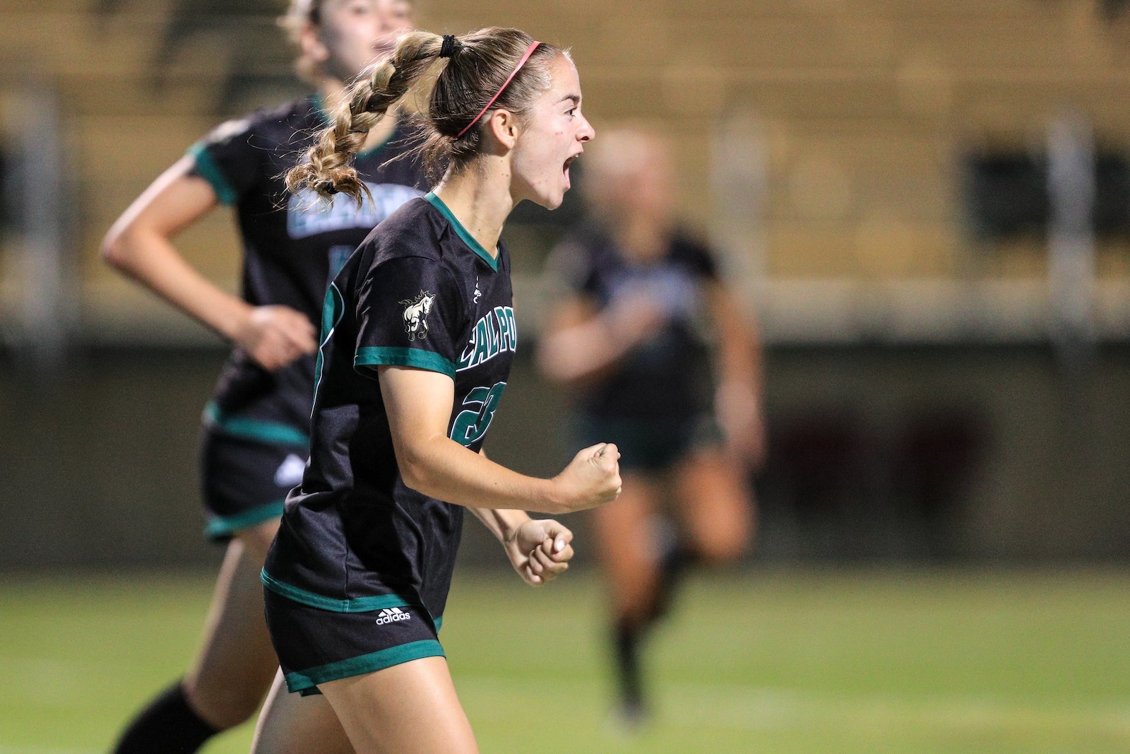 Women's Soccer member shouts with fists pumped to motivate team 