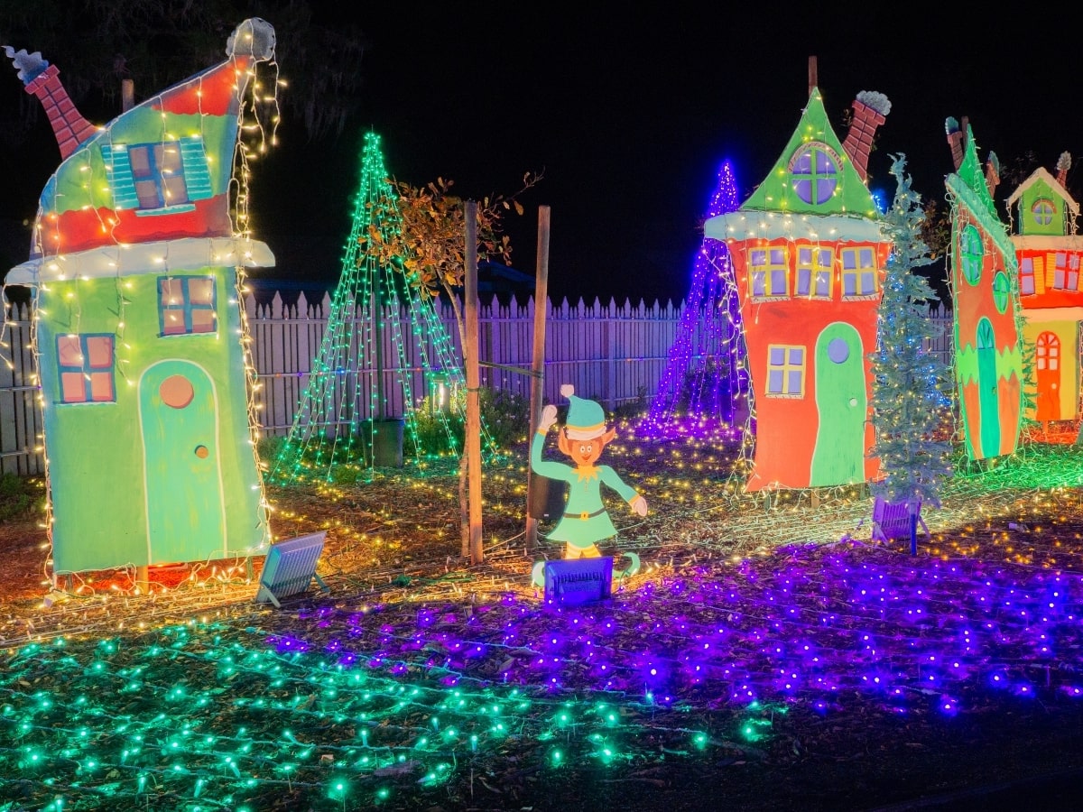 A photo of a lighted elf and three small tool sheds as part of Cambria Christmas