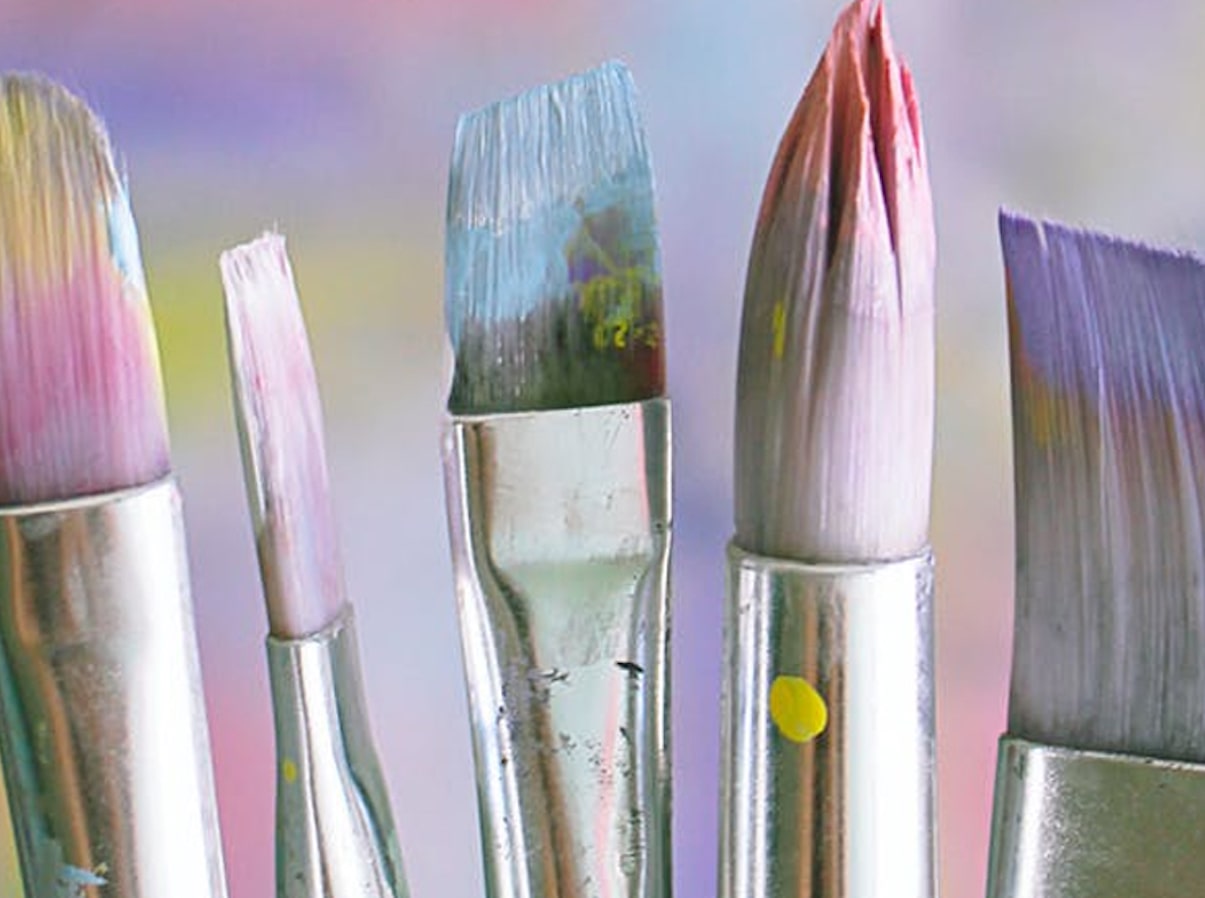 5 silver-handled paint brushes saturated in various pastel-colored paints 