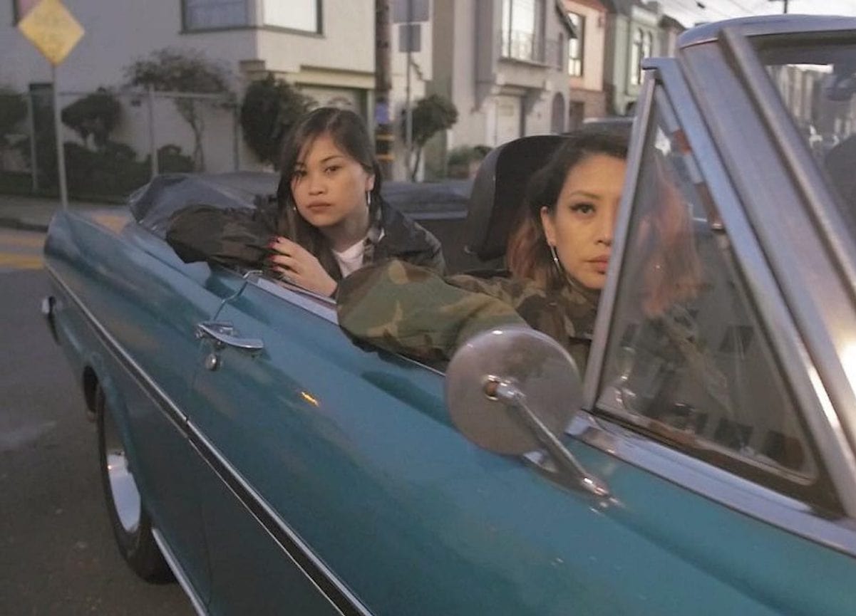Ruby Ibarra sits in back seat of blue convertible