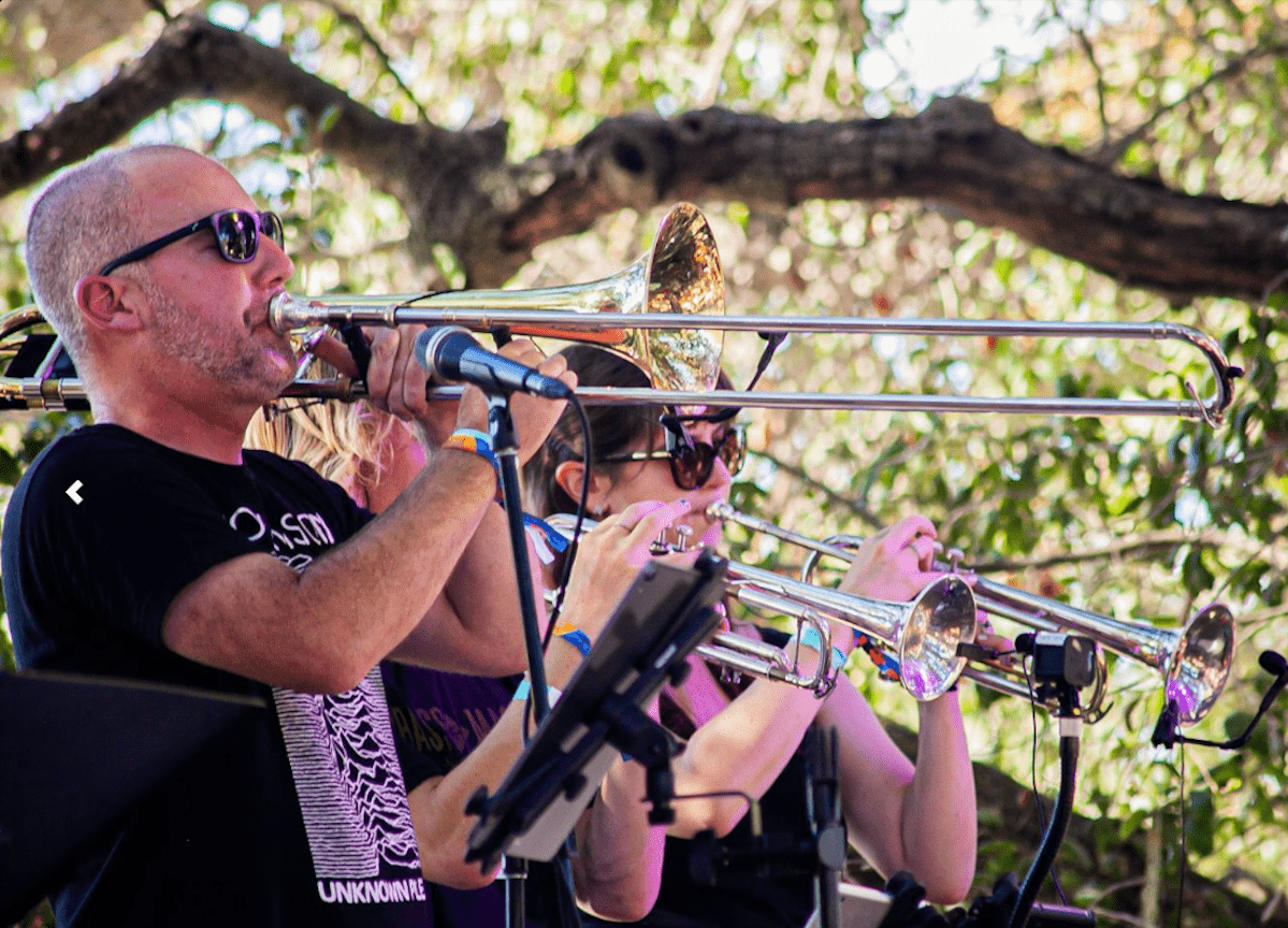 Members of the band perform outside on stage