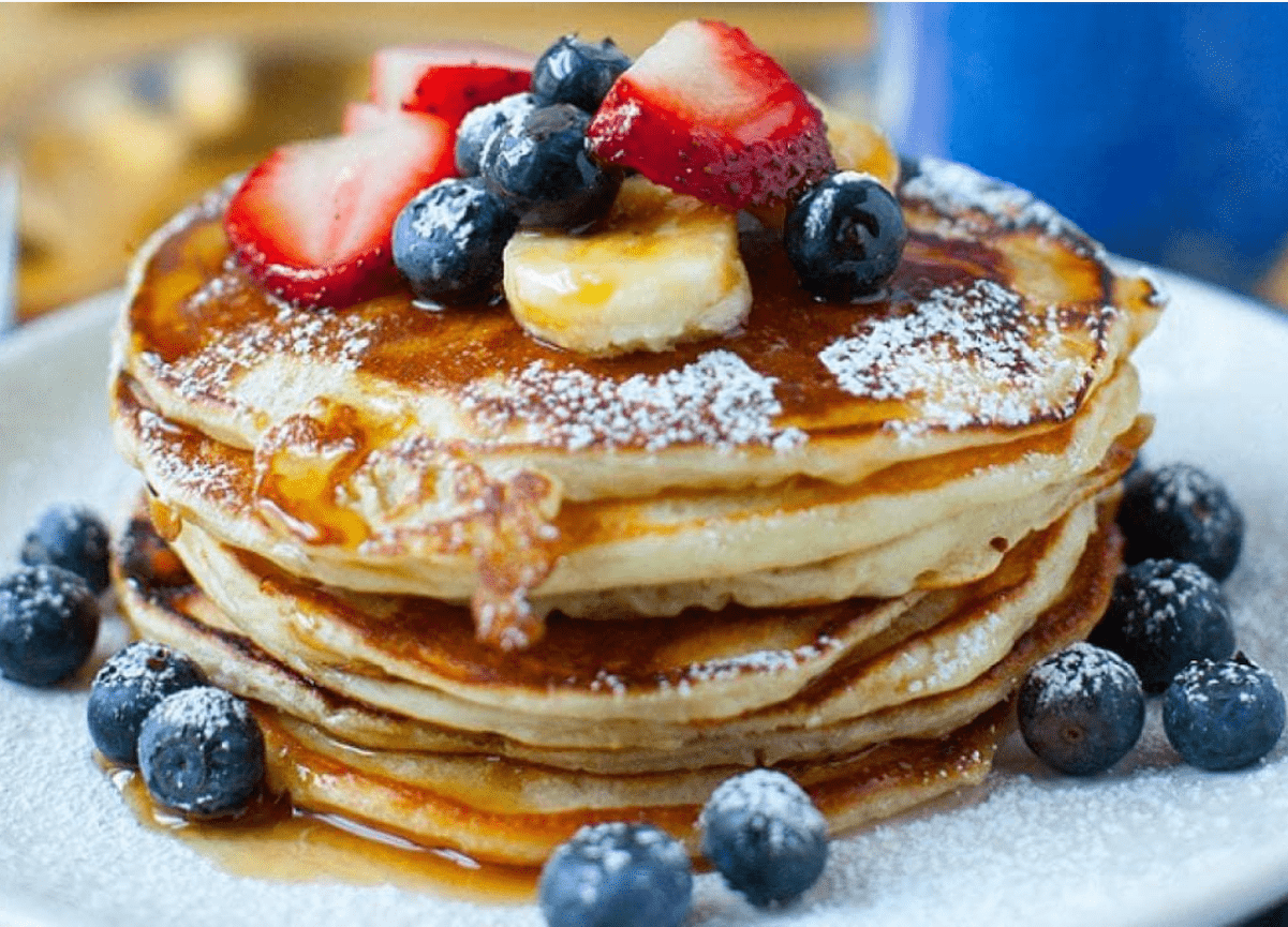 Stack of pancakes with blueberries and strawberries