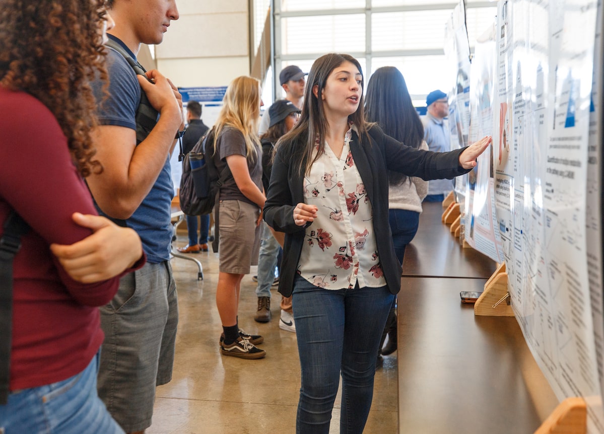 Student shares research findings with symposium attendees