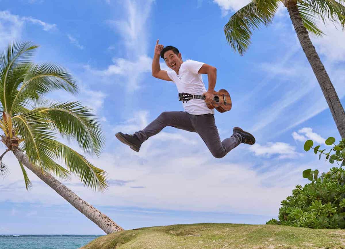 Jake Shimabukuro dives through the air with his Ukulele in an altered photo.