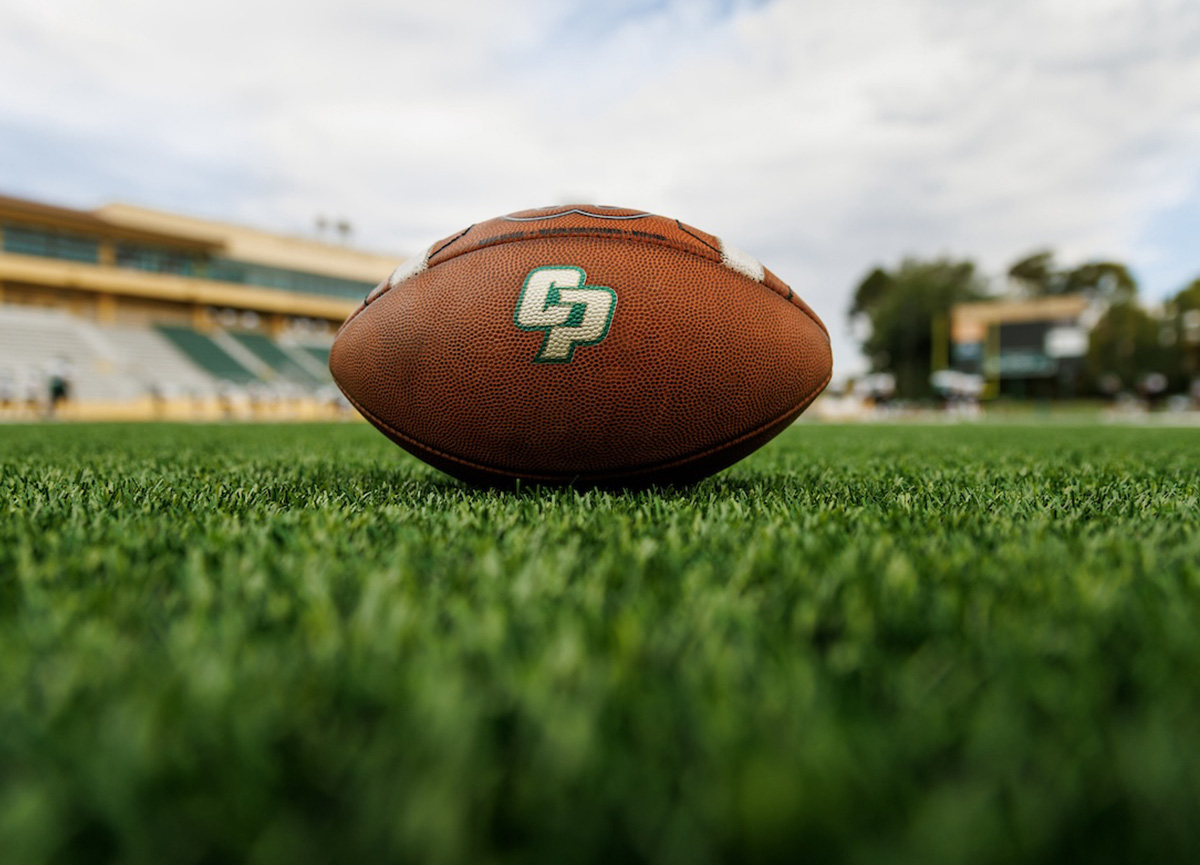 Football on field with Cal Poly athletics logo.