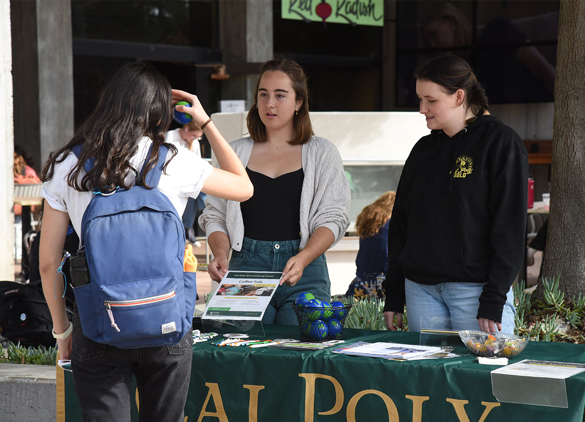 Students interacting at an outdoor tent.