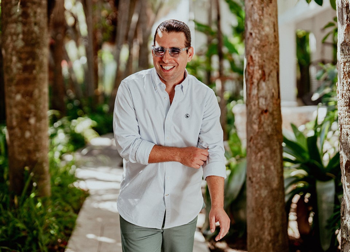 Alfredo Rodriguez with sunglasses walking on a pathway.