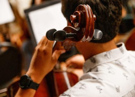 Cellist in Cal Poly Symphony pictured from behind. 